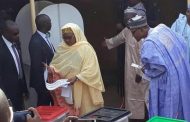 President Buhari Stares Curiously at Wife's Ballot Paper